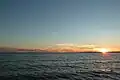 Sun setting over ocean waters