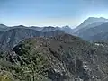 Mt. Tavagnone and its pastures of the former Battista Corsetti "Prandini" Fund, Dos di Sas and the Vein Pass on the far right, and ascending the ridge on the left three mountains, Mt. Gas respectively of 1,128 m., and two other unknown ones of 1,143 m., 1,067 m., while in the background the artificial lake of Valvestino, Mt. Pizzocolo, Mt. Castello and Lake Garda with the Sirmione peninsula.