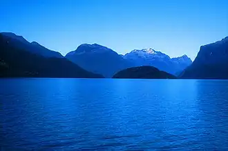 A still lake with mountains in the background on a clear day