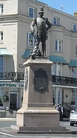 Bronze statue of a soldier atop a decorative obelisk