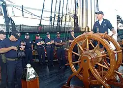U.S. Navy personnel aboard USS&nbsp;Constitution, by the ship's wheel