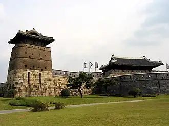 Wall, tower and roofs of one larger building of a fortress.