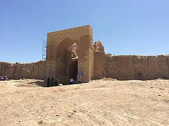 دروازه اصلی کاروانسرای دایه‌خاتون قرن یازدهم در ولایت لب آب، ترکمنستان. این دروازه از آجرهای خشتی ساخته شده و در منطقه‌ای خشک و شنی قرار دارد.