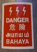 An electrical hazard sign in Malaysia written in Tamil with other languages