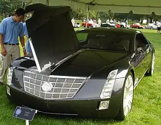 Man looking at Cadillac Sixteen with open hood.