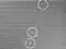 A noisy image showing a few bright dots marked by circles