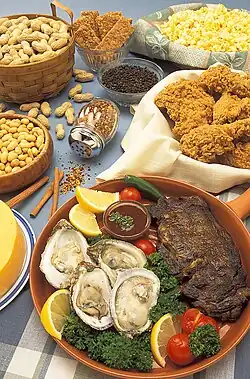 چندین بشقاب پر از غلات، میوهها و سبزیجات مختلف بر روی یک میز.