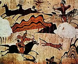 Mural of men on horses with bows and arrows shooting deer.