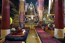 Temple interior with pillars, resting places and a statue