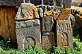 Khachkars lining the exterior wall of the church.