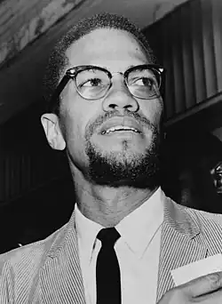 Black-and-white photograph of Malcolm wearing a suit