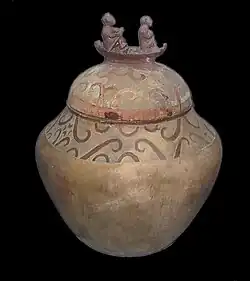 کوزهای با درپوش تزئینشده با دو نفر روی یک قایق