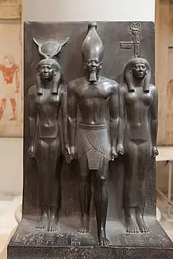 مجسمه سه‌گانه فرعون منکورع، همراه با الهه حاتحور (در سمت راست او) و شخصیت نام دیوسپولیس پروا (در سمت چپ او). جنس: ماسه‌سنگ. ابعاد: ارتفاع ۹۳ سانتی‌متر عرض ۴۷ سانتی‌متر