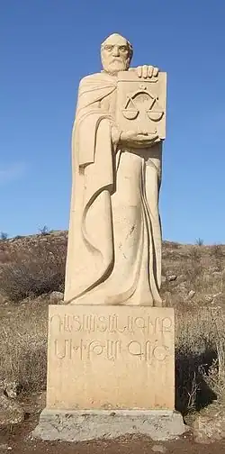مجسمه مخیتار گُش در ارمنستان که کتاب حقوق در دستش میباشد