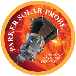 Artwork of the spacecraft next to the sun, enclosed in a circle with a yellow border. The words "Parker Solar Probe" are placed around the interior of the border, while the words "a mission to touch the sun" are written inline in a smaller font in the bottom right of the image.