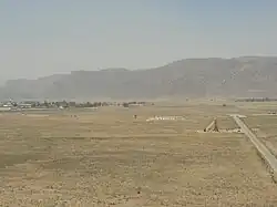 نمای پاسارگاد از روی تپه تل‌تخت. آرامگاه کوروش بزرگ دورترین بناست که در قسمت مرکزی بالای تصویر دیده می‌شود.