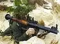 پرتابگر یک آرپی‌جی۷ روسی خود را با شاخ و برگ استتار کرده‌است