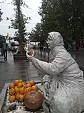 اصطلاح بازارمج در زبان گیلکی به دستفروشان محلی گفته میشود. (مجسمه پیاده راه مجموعه میدان، ساختمان و کتابخانه شهرداری رشت)