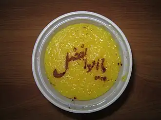 لقب عباس بن علی (ابوالفضل) که با دارچین آسیاب شده بر روی غذای سنتی ایرانی موسوم به شله‌زرد نوشته شده‌است. این نوع اسم‌نویسی را بر روی غذاهای نذری انجام می‌دهند.