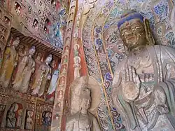 Buddhist deities of various sizes carved from rock and painted in many colors.