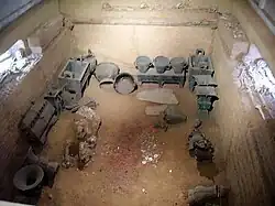 Archaeological excavation of a pit with boxes and vases.