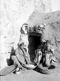 زنی در حال آماده‌سازی نان در کنار تنور طابون
