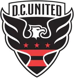 A shield with stylized black eagle facing right with three red stars and two red strips across its chest, and the words "D.C. UNITED above."