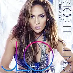 The cover art for the single, featuring a full-face view of a light-brown-skinned woman (Jennifer Lopez) posing before what appear to be white plastic curtains. She's wearing make-up, clothes and jewelry suitable for a night at the disco. Her blue party dress leaves her arms, parts of her waist and top of her chest bare. She has several silvery chains around her neck. Her hair is streaked light and dark brown and hangs down carelessly to her shoulders and below. Large, multi-colored letters in the foreground read "JLO". Sideways on the right edge are the somewhat smaller words in blue, "ON THE FLOOR" and "FEAT. PITBULL".